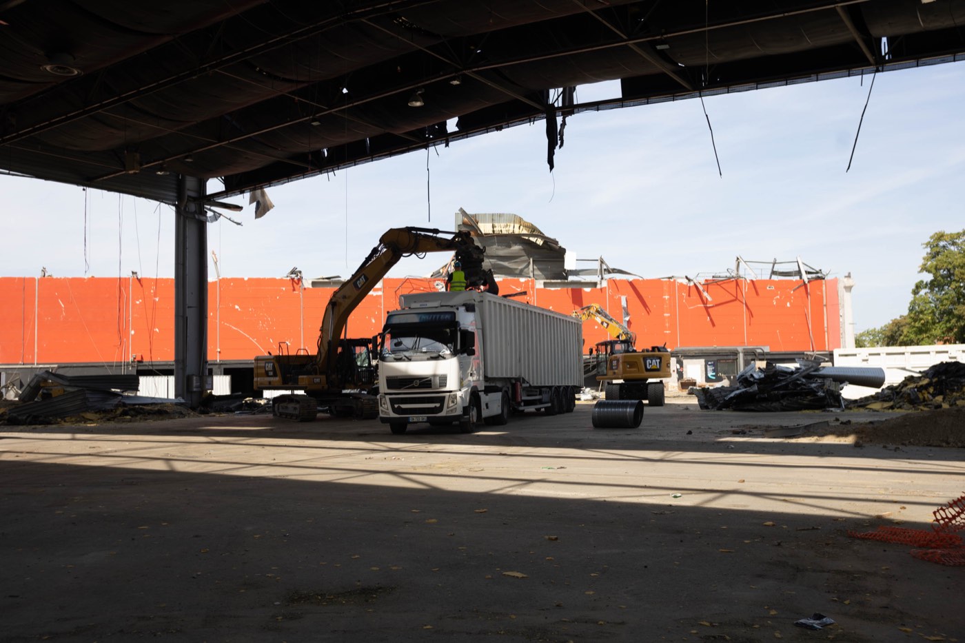 Camion d'évacuation de gravats sous une structure en déconstruction