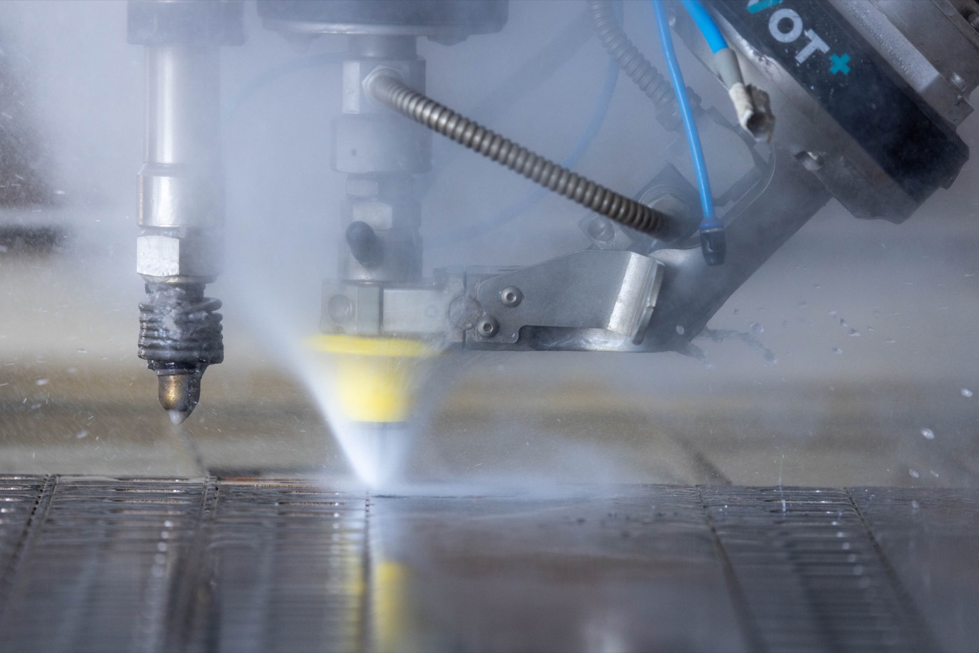Découpe jet d'eau industrielle sous nuage de vapeur