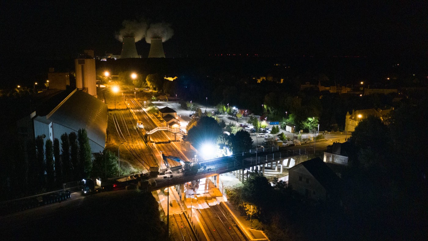 Le chantier illuminé de nuit avec les tours de la centrale de Nogent en arrière-plan